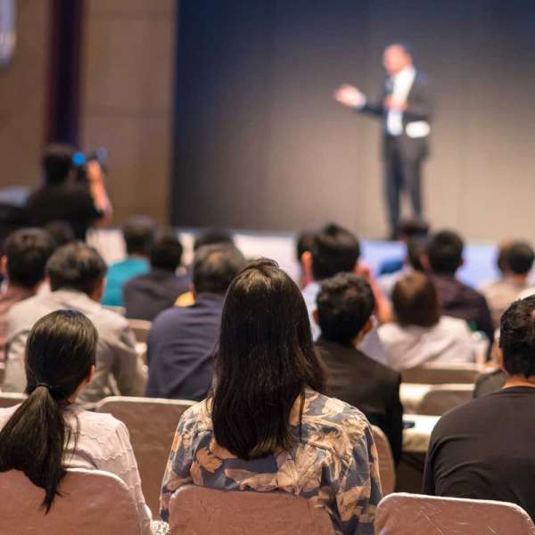 rear-side-audiences-sitting-listening-speackers-stage
